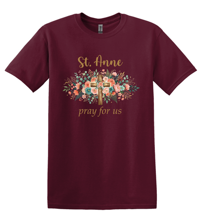 A maroon shirt with a floral cross that says "St. Anne Pray for Us"