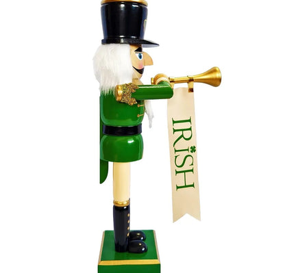 An Irish St. Patrick's Day nutcracker soldier figurine wearing a green uniform, black hat, and white beard, holding a gold trumpet with a hanging banner that reads 'IRISH'.