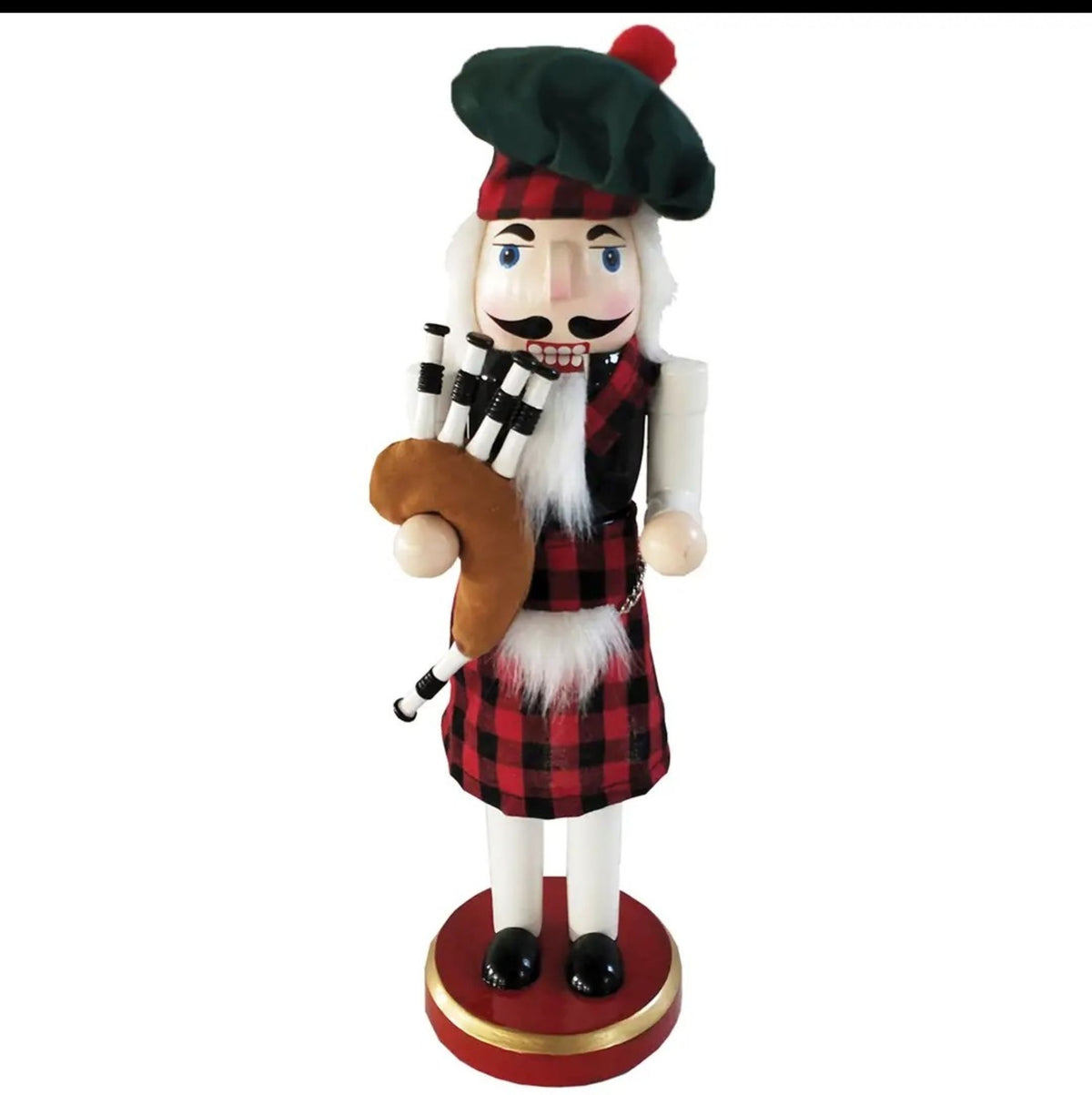 A Scottish-themed nutcracker figurine dressed in a red and black plaid kilt and matching hat, holding a bagpipe, standing on a red circular base with a gold band.