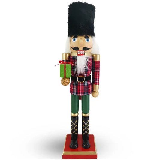 Traditional Christmas nutcracker with plaid outfit and gift on a white background