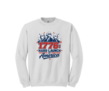 All I Need Designs white crewneck sweatshirt with "1776: Hard Launch of America" graphic featuring founding fathers in sunglasses.