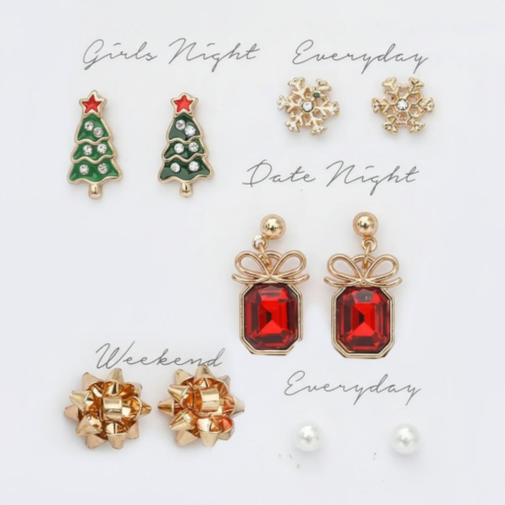 All I Need Designs 5-pair holiday earring set featuring Christmas trees, snowflakes, red gemstone presents, gold bows, and pearl studs.