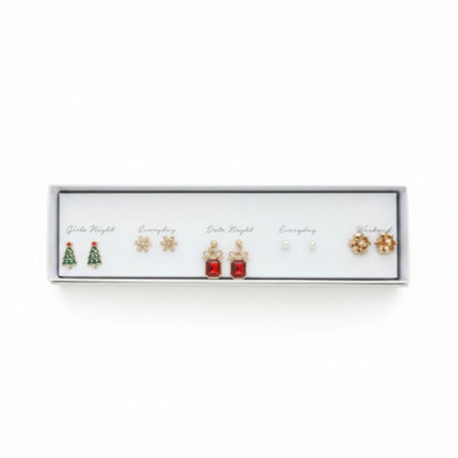 All I Need Designs 5-pair holiday earring set with Christmas trees, snowflakes, red gems, pearls, and gold flowers.