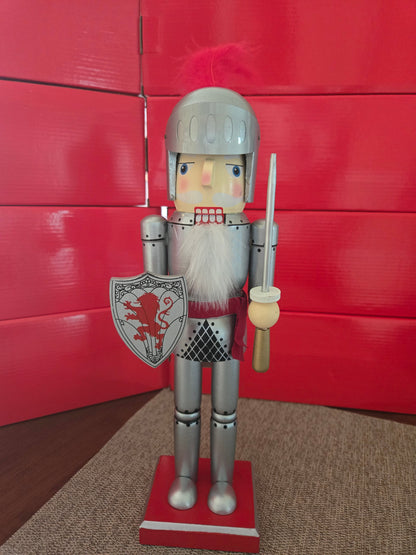 All I Need Designs 14" wooden knight nutcracker in silver armor with red plume, shield, and sword.