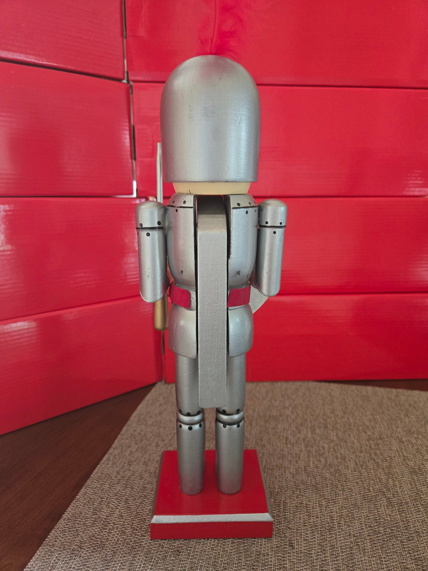 All I Need Designs 14-inch wooden knight nutcracker in silver armor with red accents and a red plume.