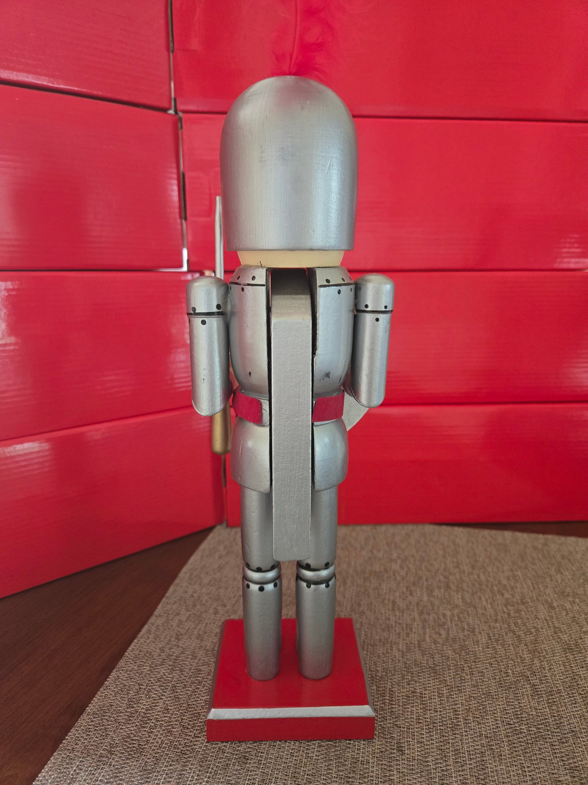 All I Need Designs 14-inch wooden knight nutcracker in silver armor with red accents and a red plume.