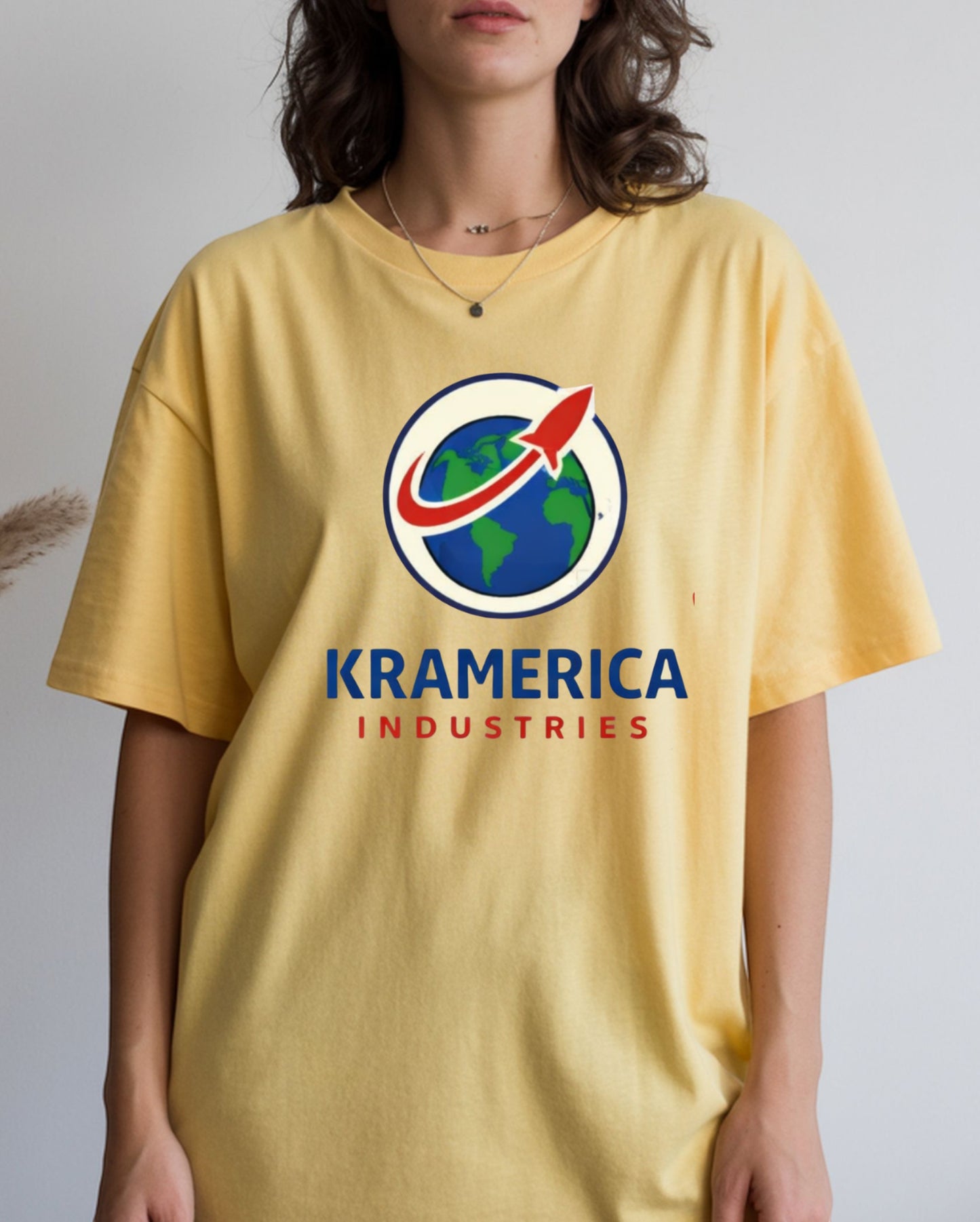 All I Need Designs yellow unisex softstyle t-shirt with Kramerica Industries graphic logo. Cotton blend.
