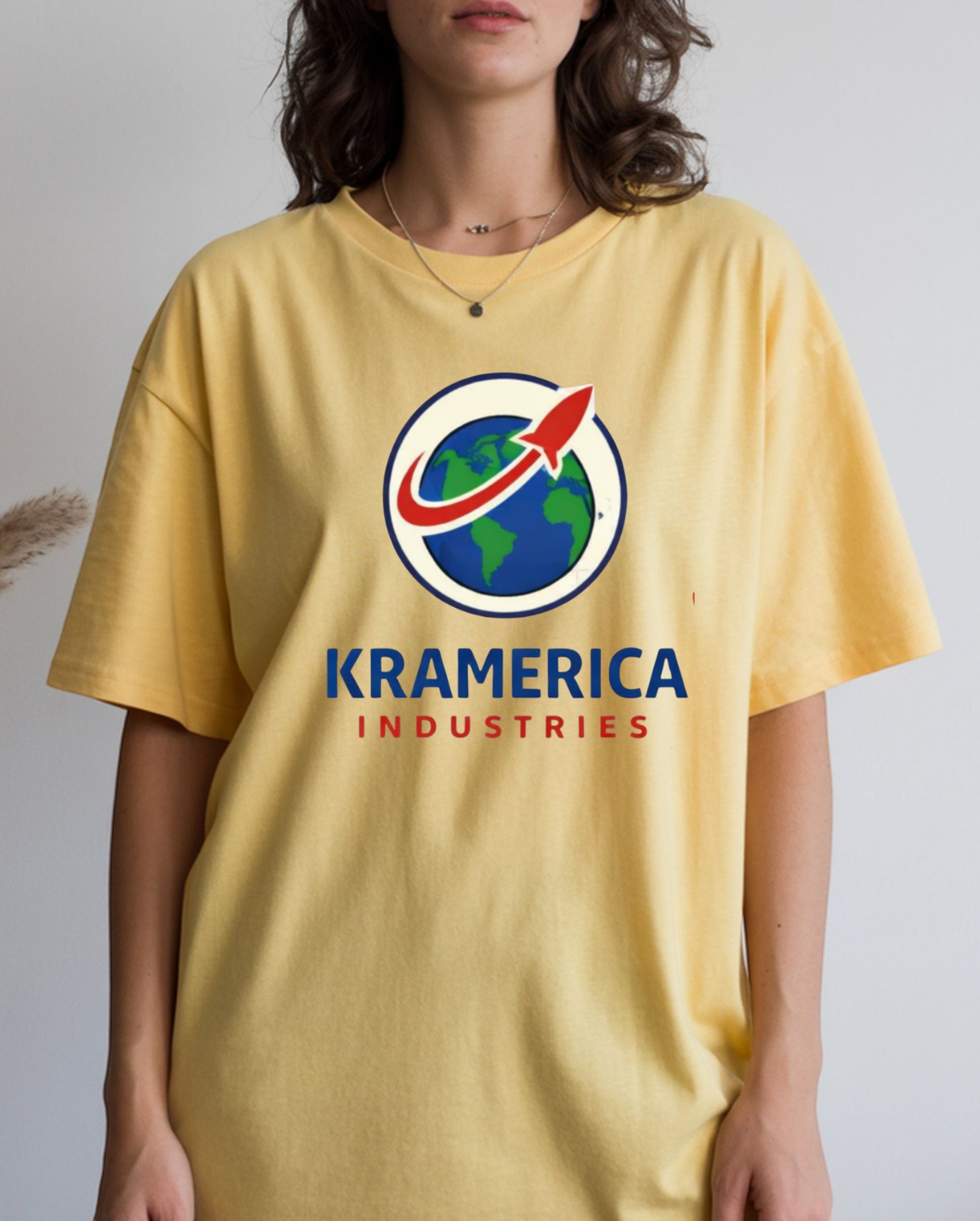 All I Need Designs yellow unisex softstyle t-shirt with Kramerica Industries graphic logo. Cotton blend.