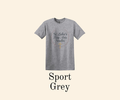 All I Need Designs Sport Grey t-shirt with St. Luke's Fine Arts Studio text and gold cross within a laurel wreath.