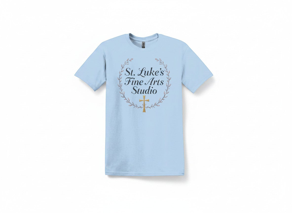 All I Need Designs light blue cotton blend t-shirt with St. Luke’s Fine Arts Studio and gold cross design.
