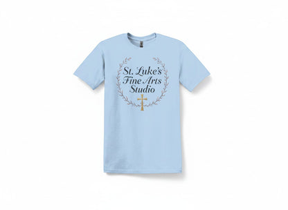 All I Need Designs light blue cotton blend t-shirt with St. Luke’s Fine Arts Studio and gold cross design.