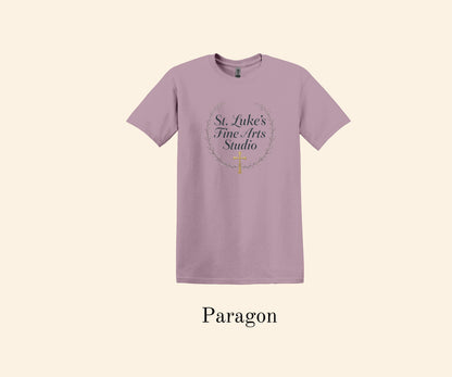 All I Need Designs St. Luke’s Fine Arts Studio t-shirt in paragon color with gold cross and laurel wreath design. Cotton blend religious art shirt.