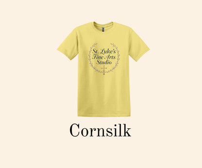 All I Need Designs Cornsilk yellow cotton blend t-shirt with St. Luke's Fine Arts Studio and gold cross design.